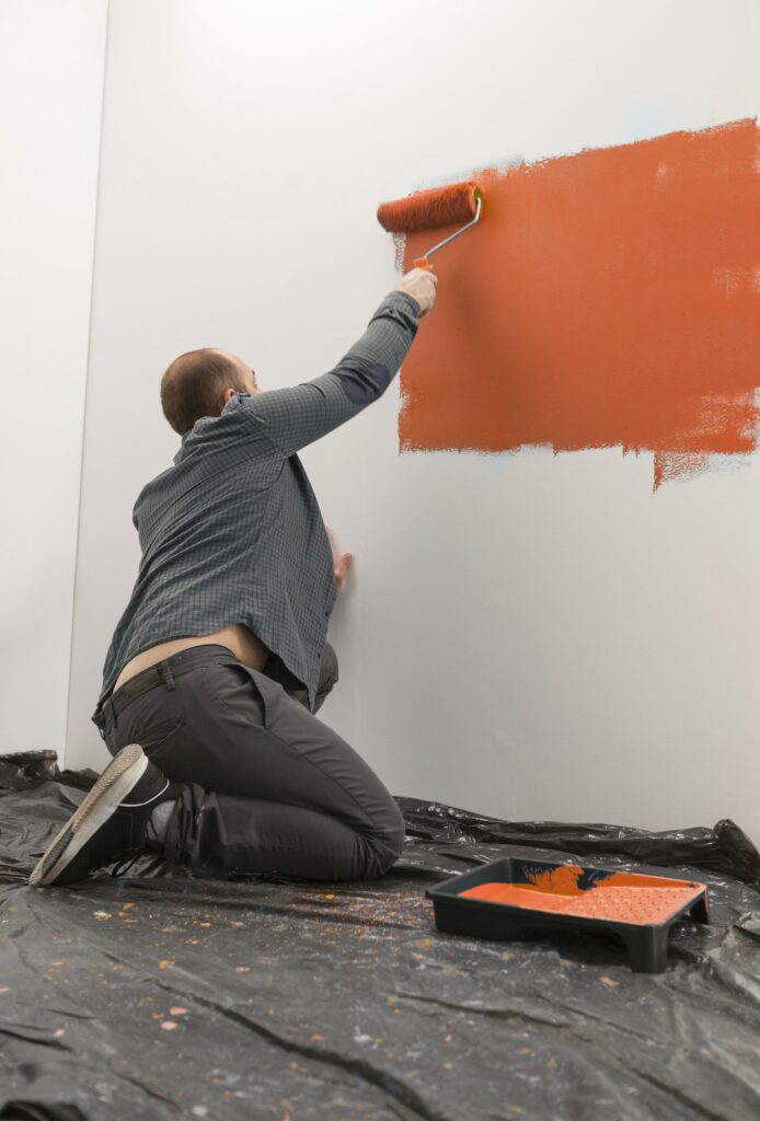 Homeowner painting wall with orange paint
