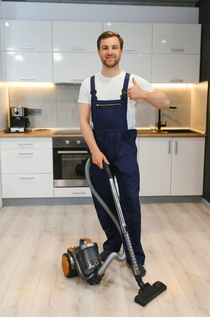 Man cleaning in the flat with vacuum cleaner